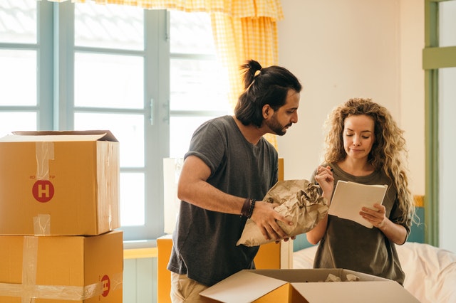 A couple looking at list of things to do when moving into a new home.